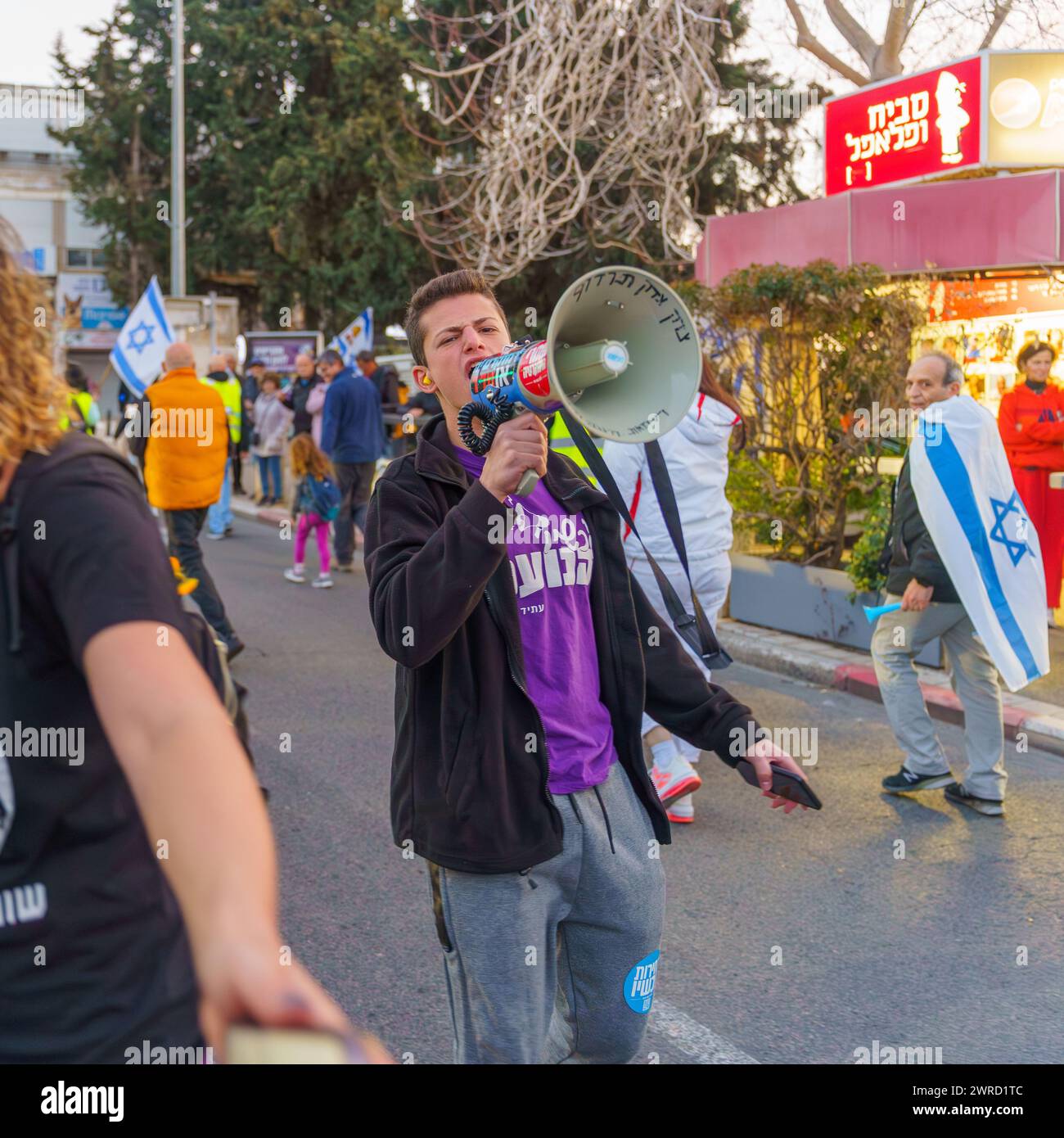 Haifa, Israele - 9 marzo 2024: La gente partecipa a una marcia di protesta, con vari segni e bandiere, contro il governo, che chiede nuove elezioni. Foto Stock