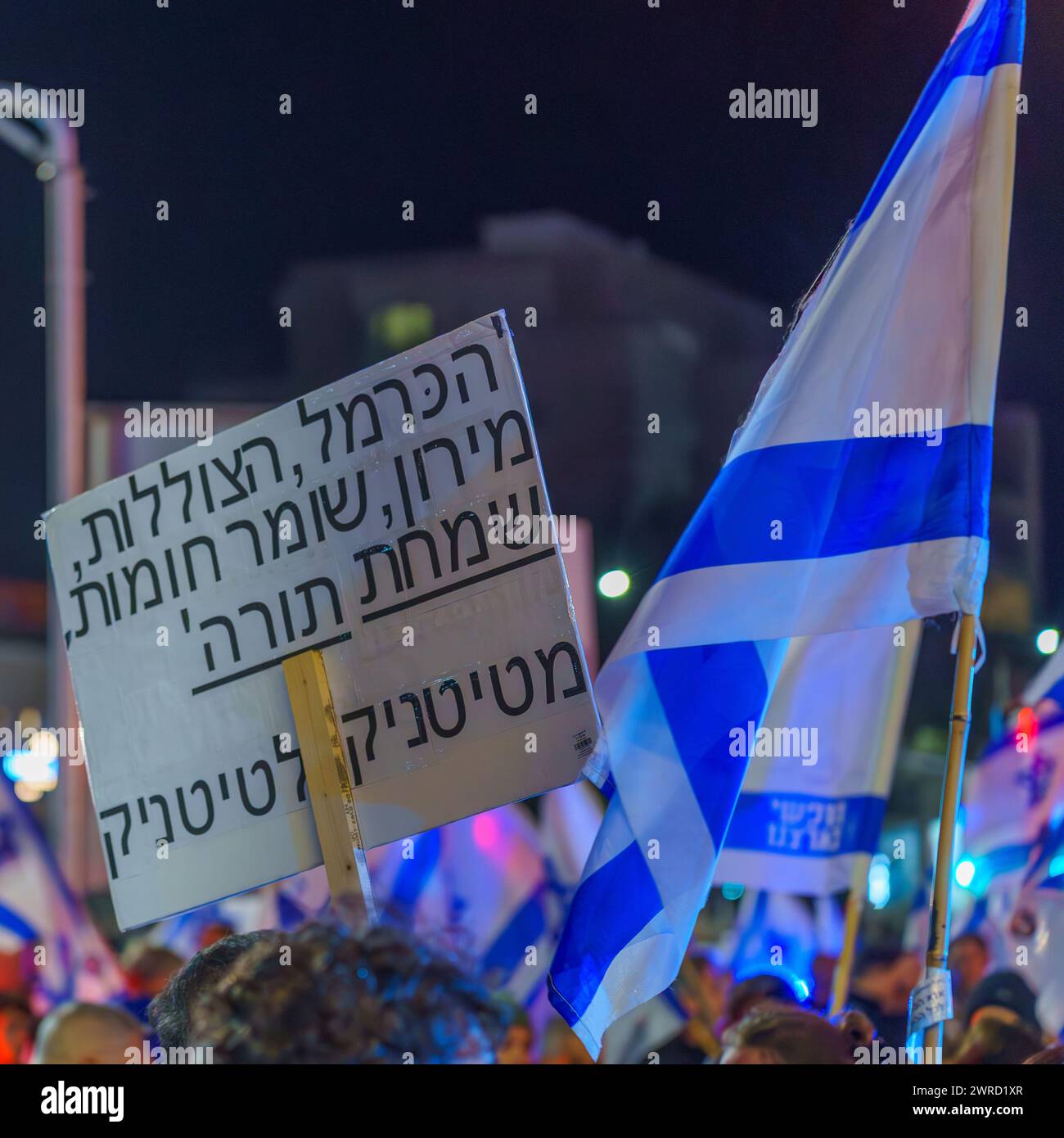 Haifa, Israele - 9 marzo 2024: Una folla di persone con vari segni e bandiere protesta contro il governo, chiedendo nuove elezioni. Haifa, Israele Foto Stock