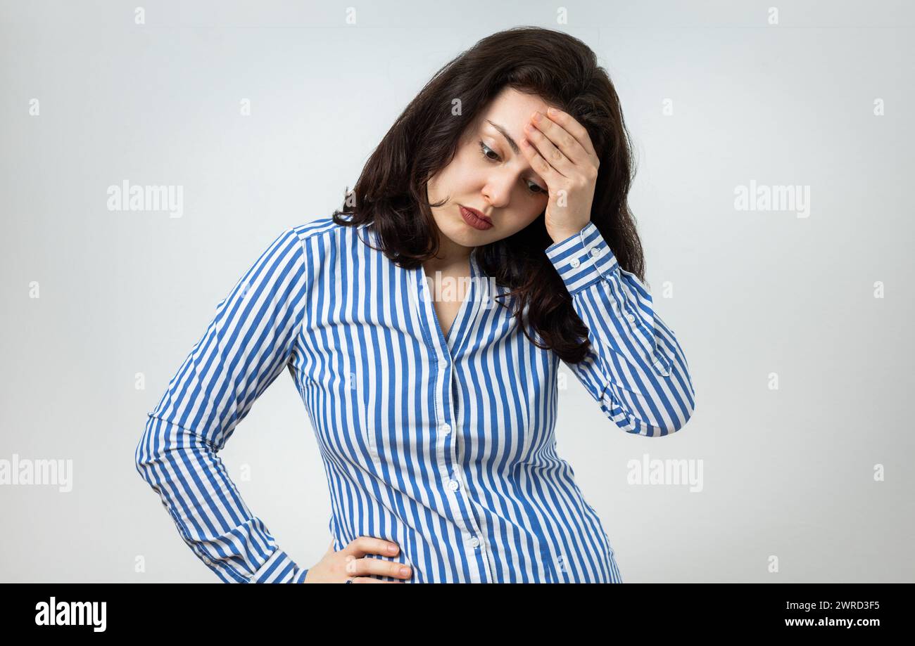 Giovane donna delusa, insoddisfatta, triste e frustrata, che esprime sentimenti negativi. Isolato su sfondo grigio chiaro. Foto Stock