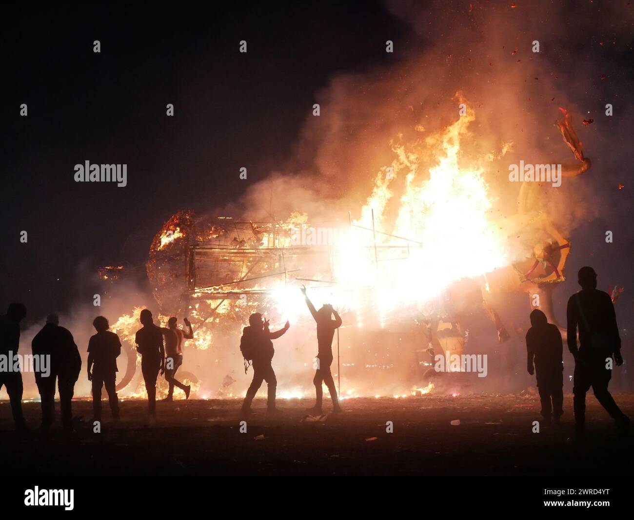 Un gruppo di persone si riunì intorno a un fuoco di terra, alcuni tenevano le torce Foto Stock