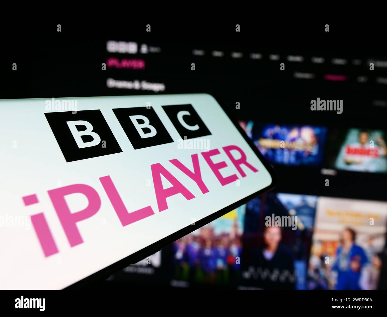 Telefono cellulare con logo del servizio di video on demand britannico BBC iPlayer davanti al sito Web dell'azienda. Messa a fuoco al centro del display del telefono. Foto Stock