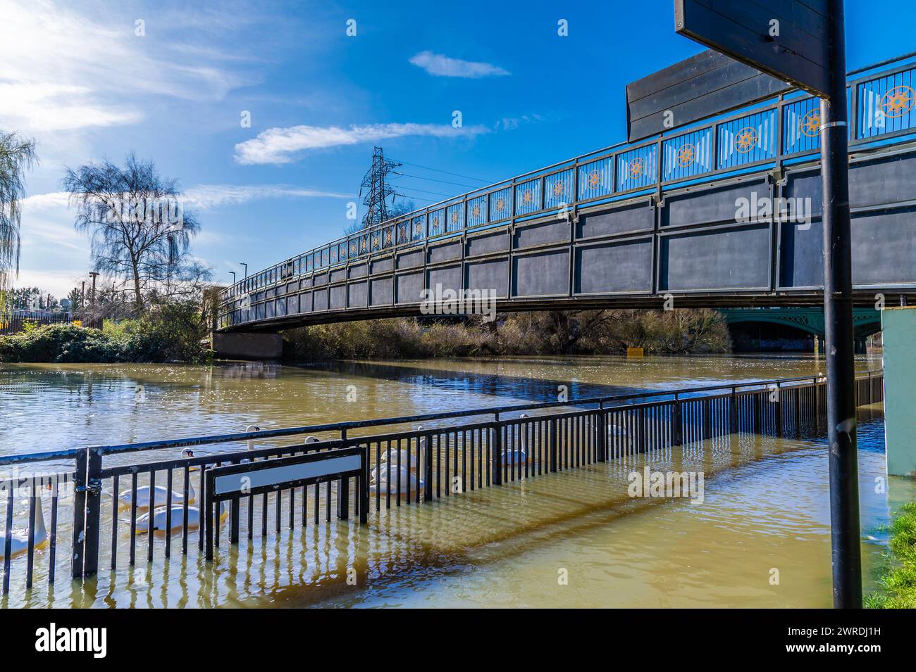 Una vista lungo un ponte pedonale sul fiume Nene a Peterborough, Regno Unito, in una giornata di sole Foto Stock