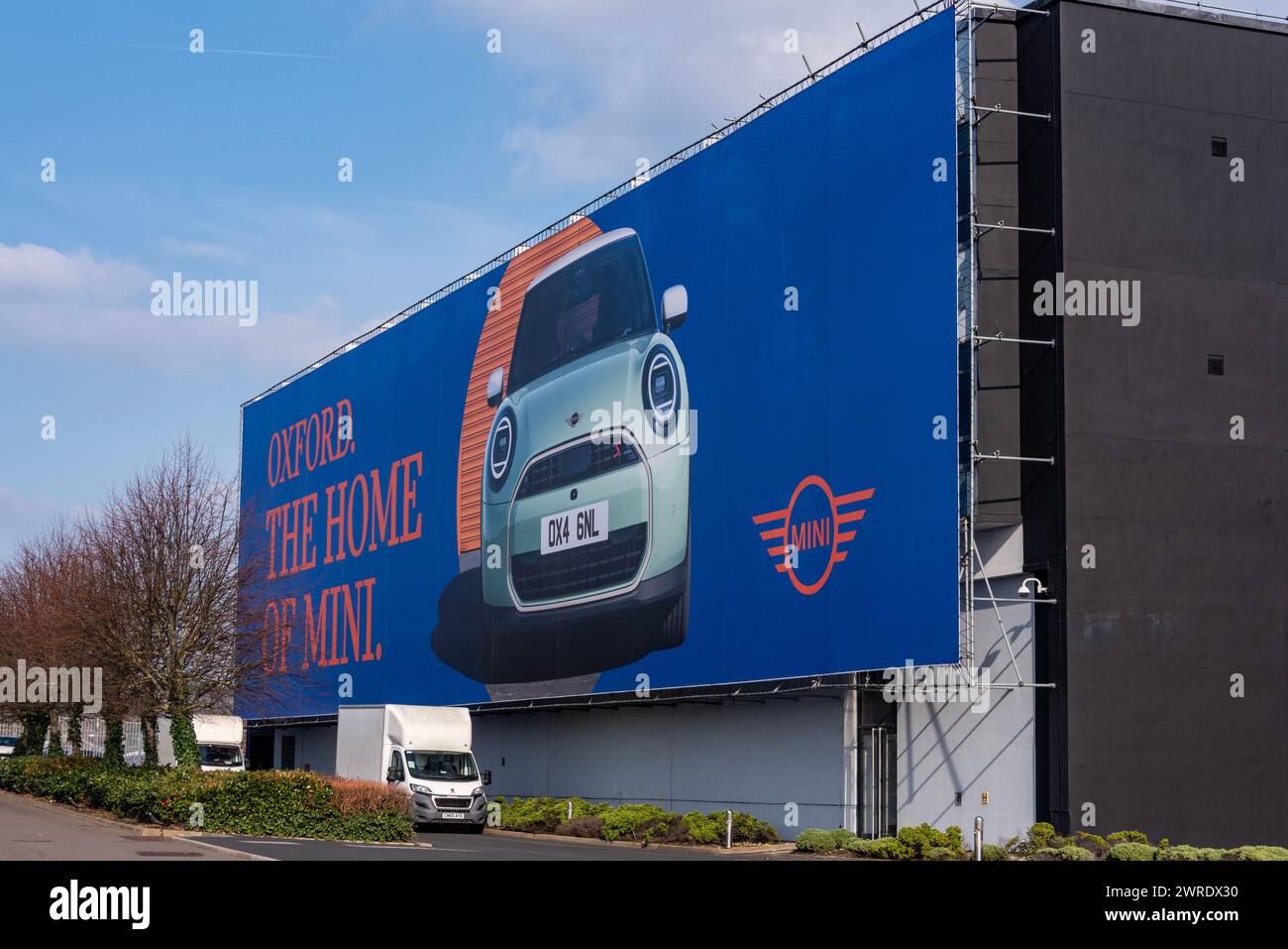 A completamento della fabbrica Mini, Oxford pubblicizza la nuova generazione 2024 Mini Cooper. NB: La foto è stata scattata attraverso la recinzione, non su Mini Land. Foto Stock