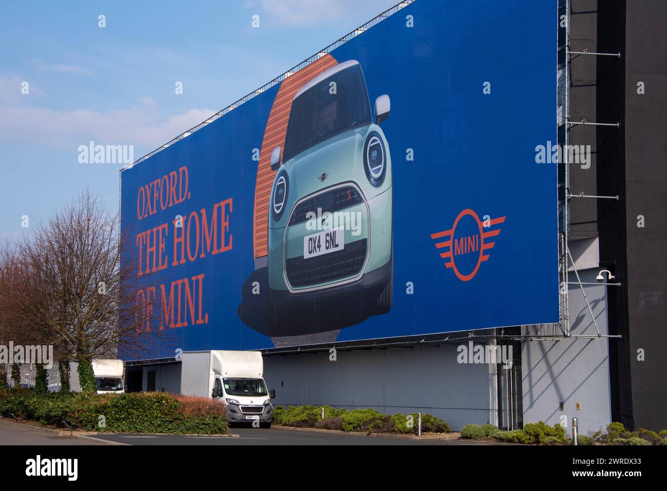 A completamento della fabbrica Mini, Oxford pubblicizza la nuova generazione 2024 Mini Cooper. NB: La foto è stata scattata attraverso la recinzione, non su Mini Land. Foto Stock