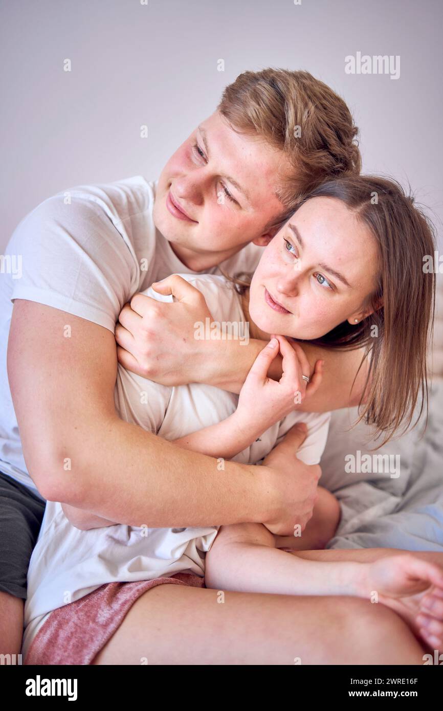 l'uomo abbraccia sua moglie da dietro, faccia a faccia Foto Stock