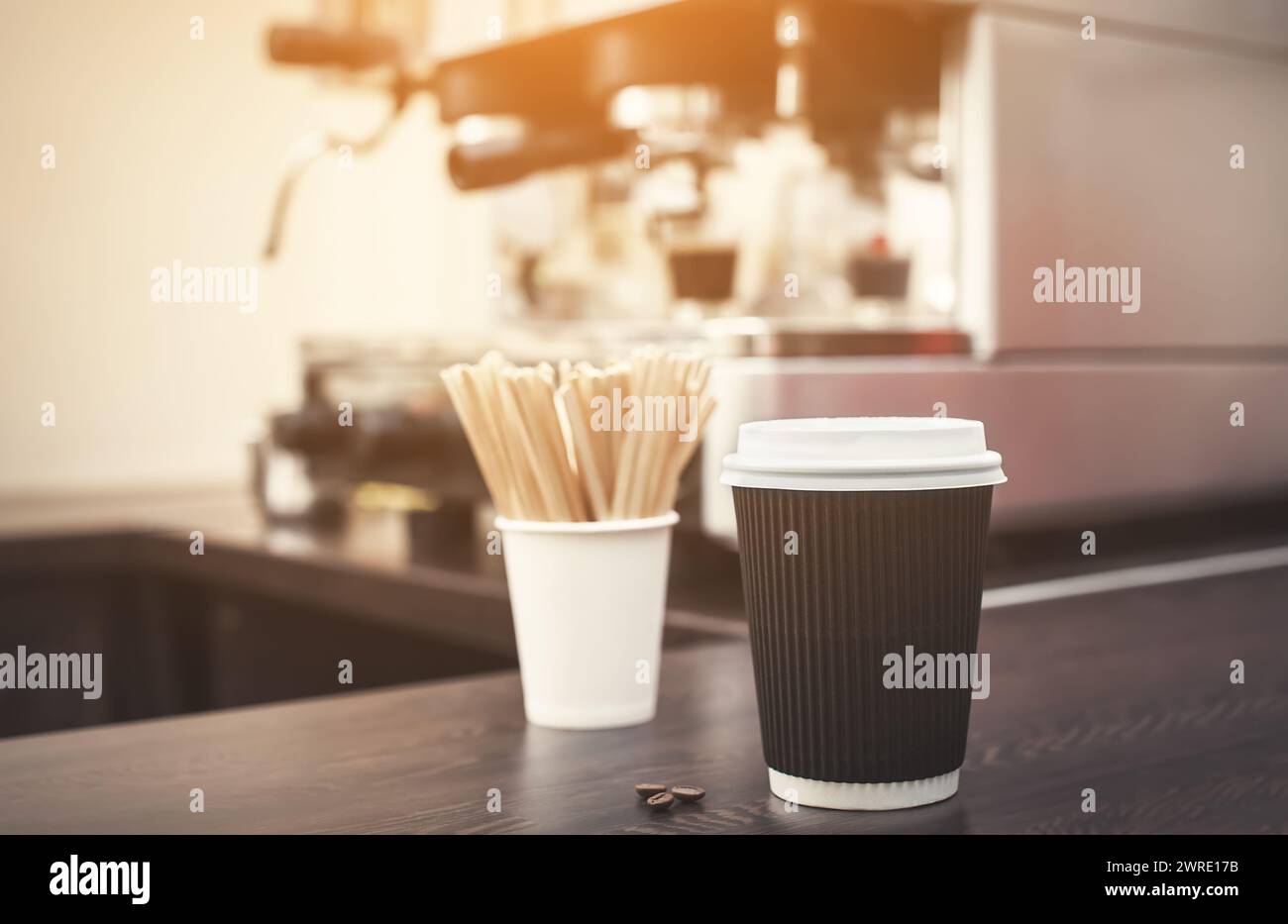 Un bicchiere di caffè nero è sul tavolo, sullo sfondo di una macchina da caffè elettrica in un caffè. Foto Stock