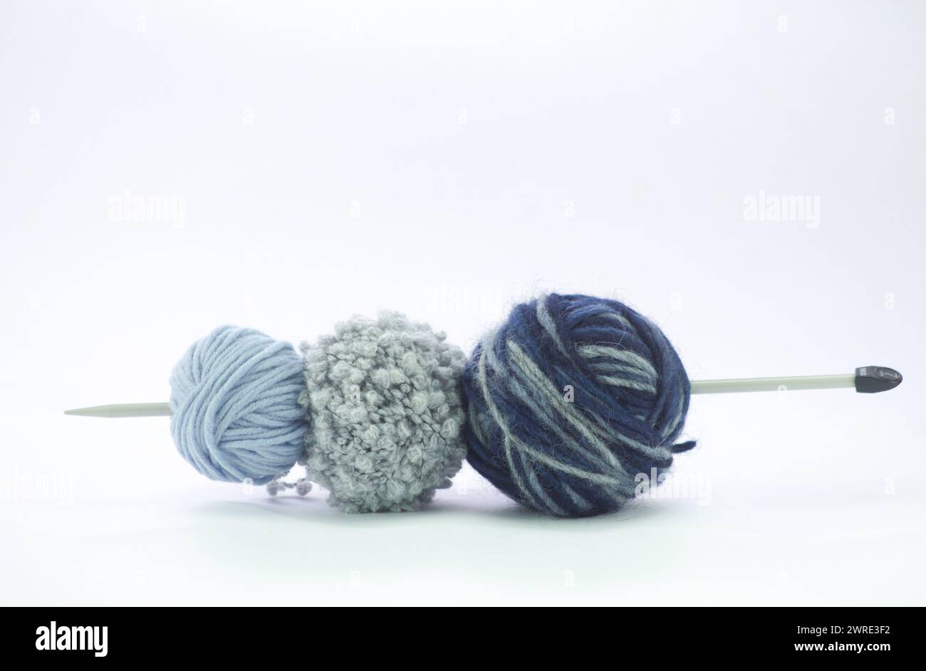 palle di lana sulle sfumature blu in diversi filati isolati sul bianco Foto Stock