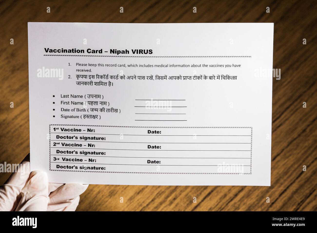 L'immagine mostra come un medico detiene la nuova carta di vaccinazione contro il nuovo virus Nipah. Su sfondo di legno. Foto Stock
