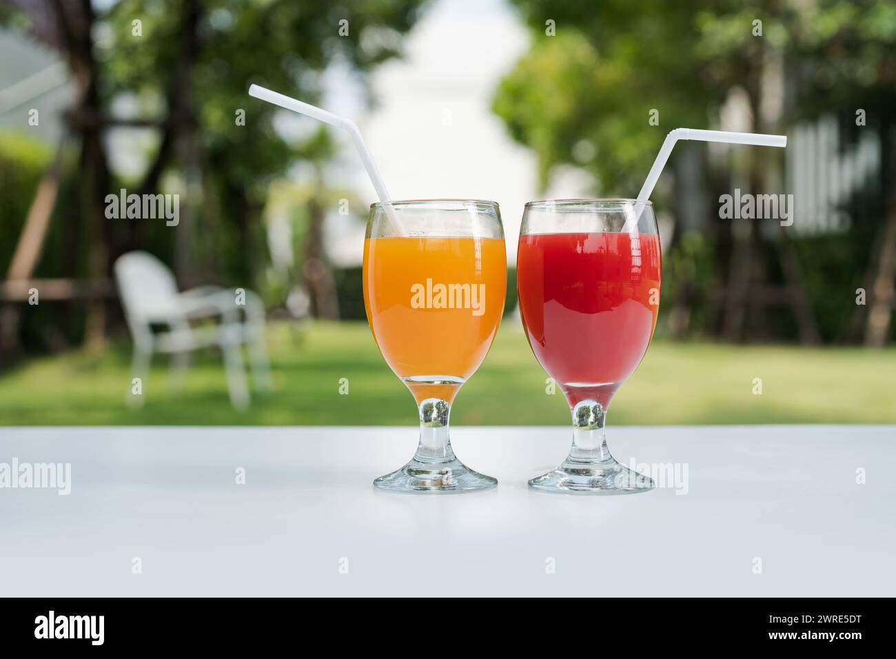 Succo d'arancia e anguria sullo sfondo naturale del giardino. Foto Stock