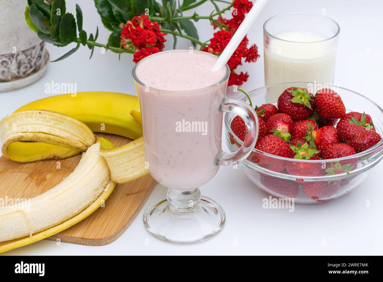 Frullati di banana e fragola, frutta sul tavolo, nel piatto, preparazione a casa Foto Stock
