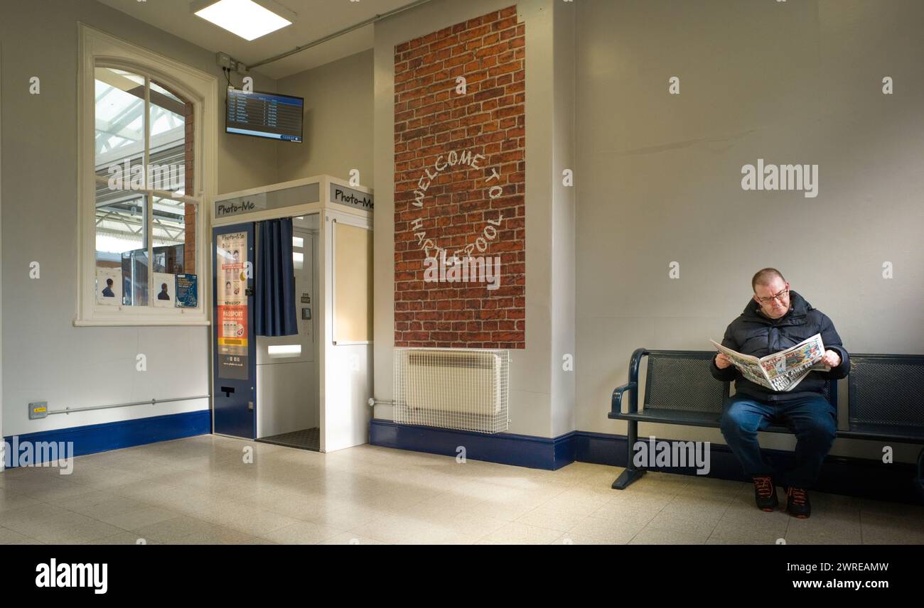 La sala d'attesa alla stazione ferroviaria di Hartlepool con l'uomo che legge il Daily Mirror Foto Stock