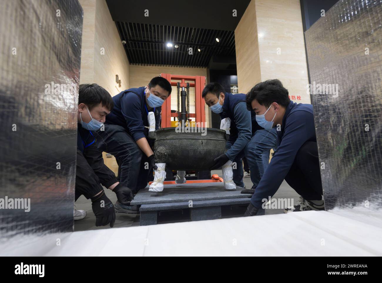 (240312) -- WUHAN, 12 marzo 2024 (Xinhua) -- i membri del personale preparano un manufatto in bronzo presso il Museo provinciale Hubei di Wuhan, nella provincia di Hubei, nella Cina centrale, 4 marzo 2024. Da aprile a luglio presso l'Asian Art Museum di San Francisco si terrà una mostra intitolata "Phoenix Kingdoms: The Last splendor of China's Bronze Age". La mostra presenterà oltre 260 manufatti provenienti da cinque musei cinesi, che illustreranno l'arte degli antichi stati Chu e Zeng. Molti dei manufatti, che includono oggetti in bronzo, lacca e giada, non sono mai stati esposti al di fuori della Cina prima. (Xinhua/Hu Jingwen) Foto Stock