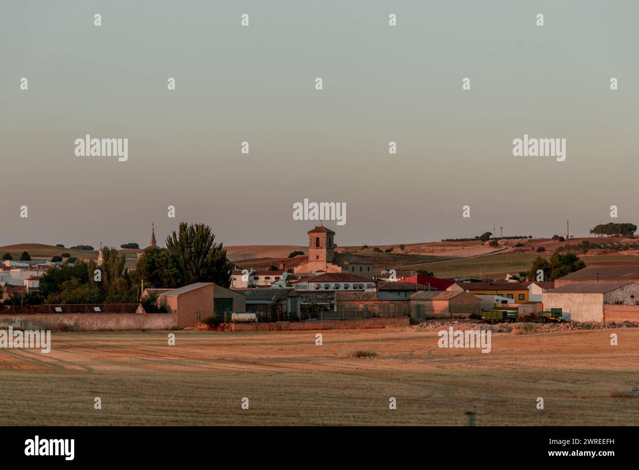 Paesaggio rurale con guglie della chiesa all'orizzonte tra alberi e piccolo villaggio Foto Stock
