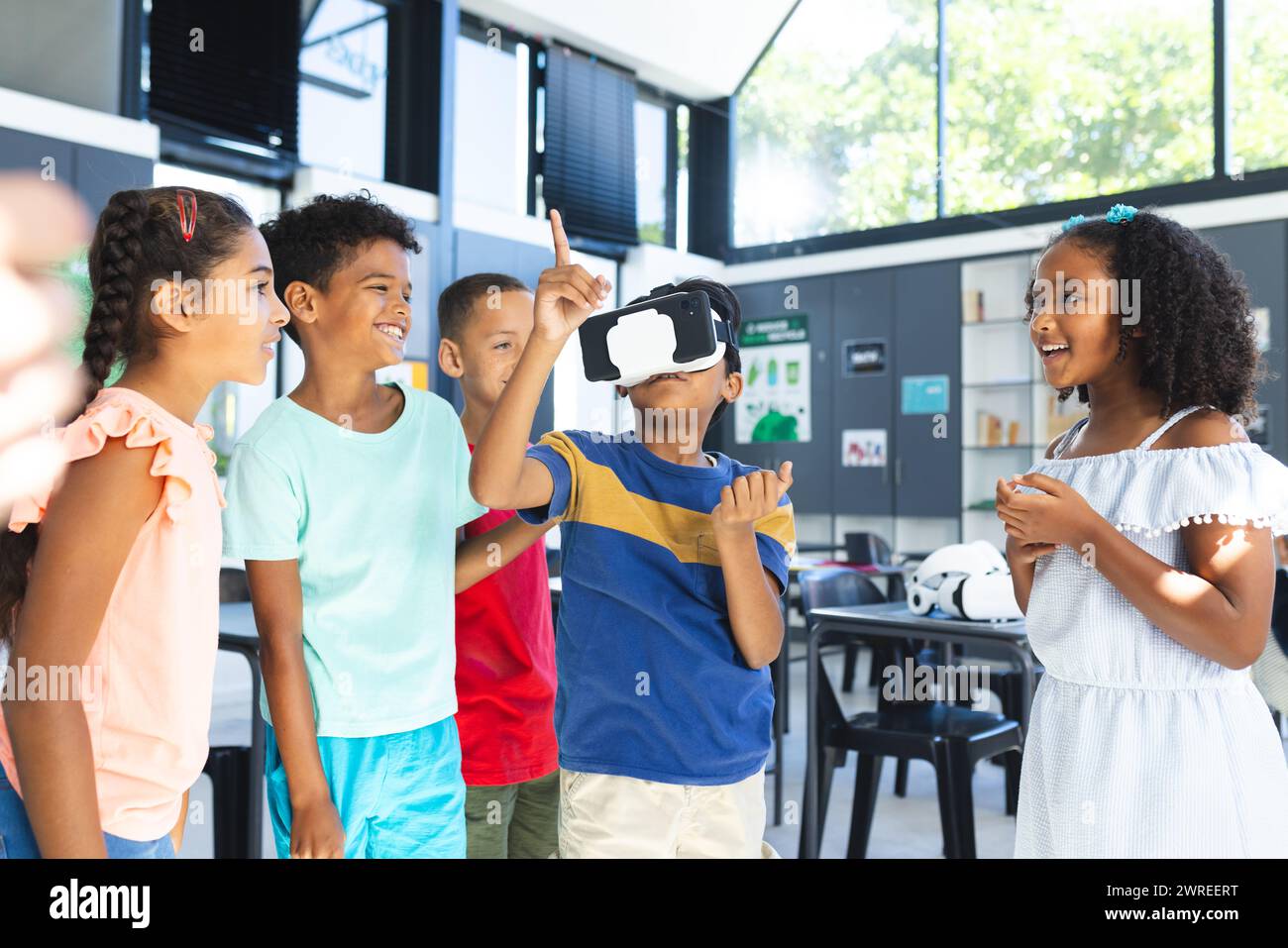 I bambini birazziali stanno esplorando la realtà virtuale in un ambiente scolastico Foto Stock