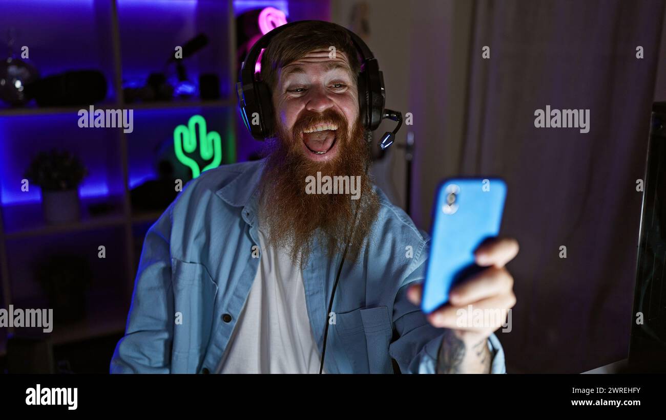 Procedura guidata per il gioco grintoso! il giovane redhead irlandese streamer ospita con sicurezza videochiamate epiche tramite smartphone nel cuore della sala giochi notturna Foto Stock