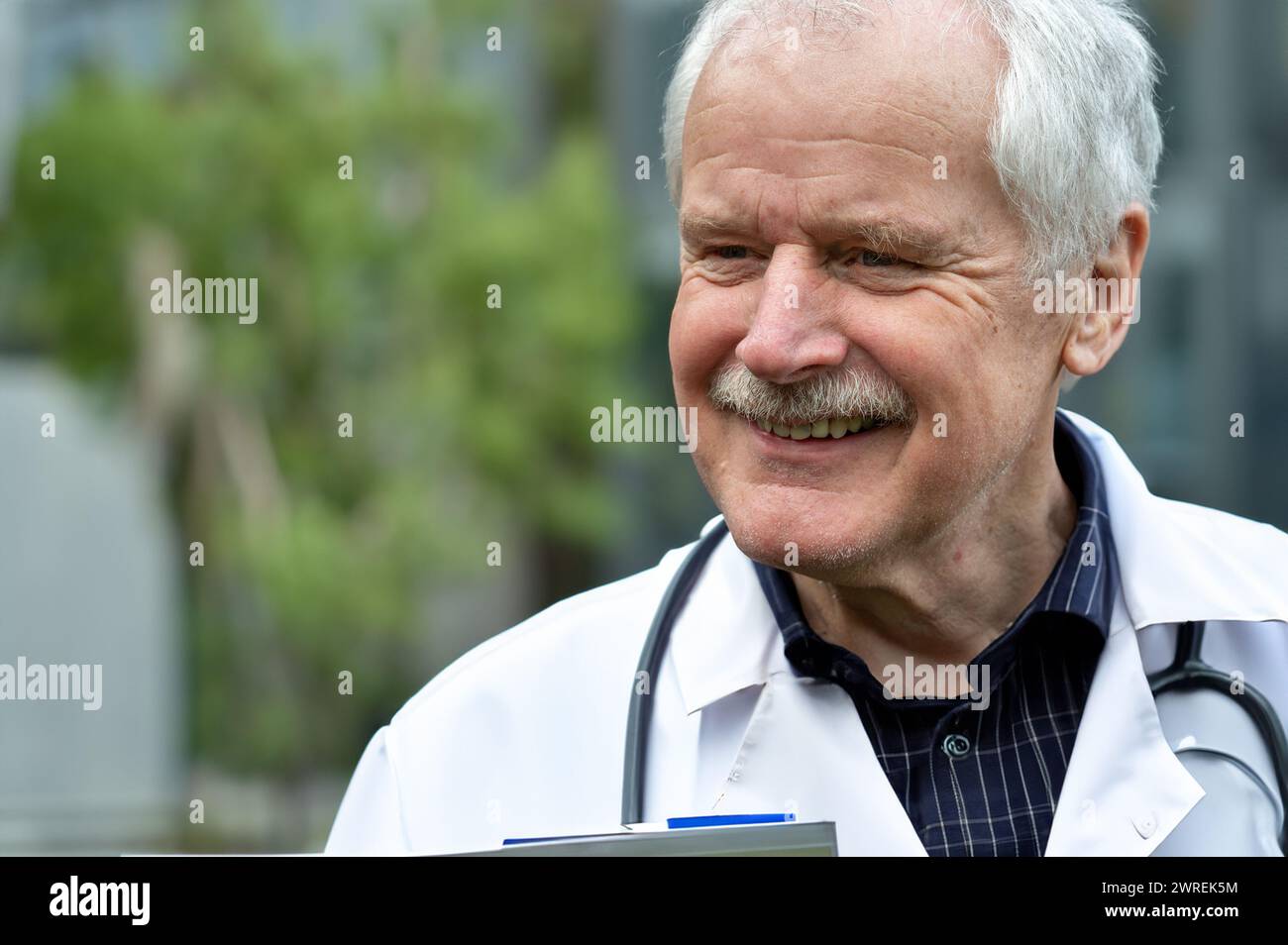 Medico anziano sorridente al paziente mentre dà la diagnosi. Foto Stock