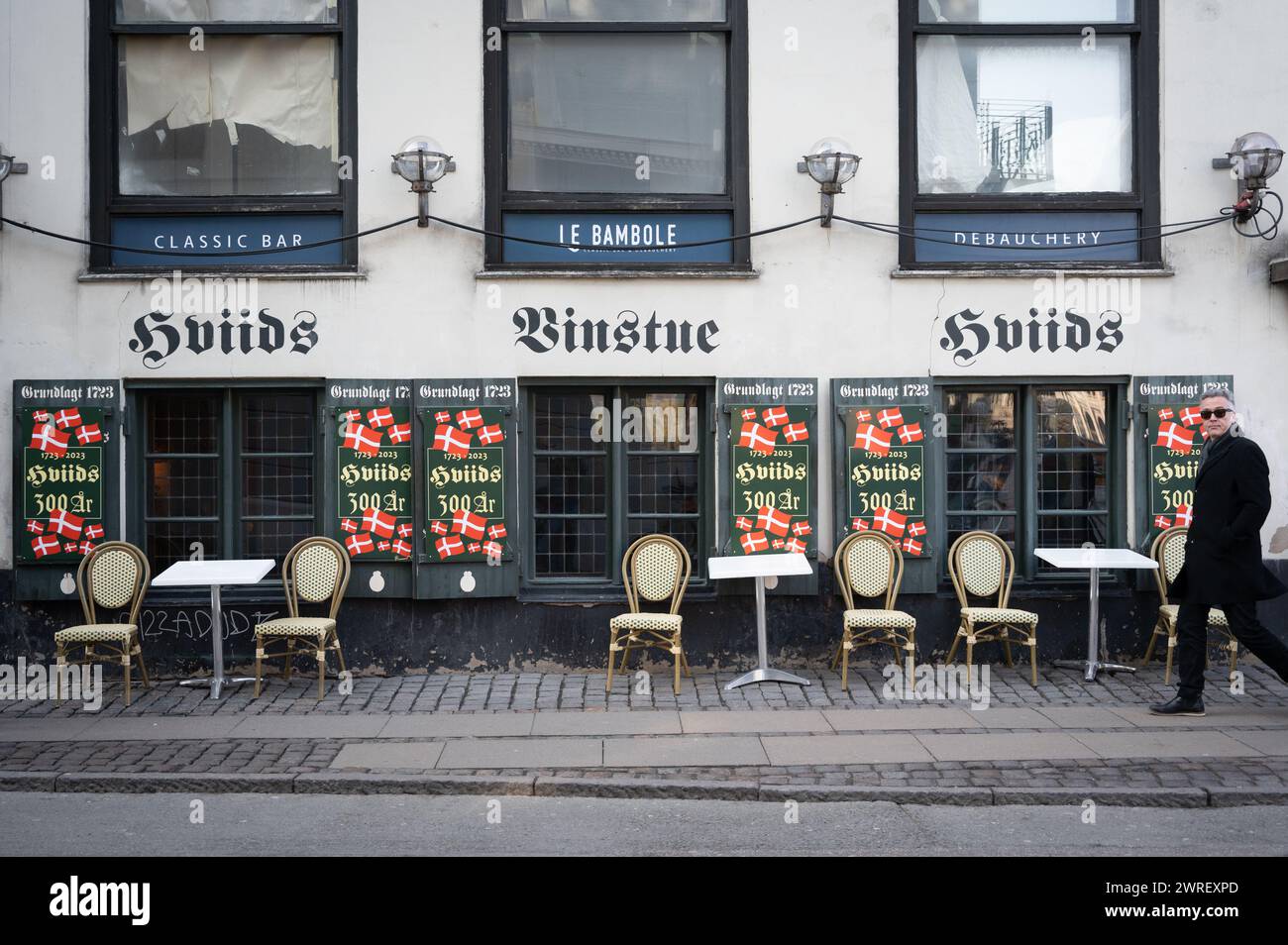 Hviids Vinstue, un popolare pub vecchio di 300 anni a Kongens Nytorv a Copenaghen, Danimarca, con bandiere danesi all'aperto Foto Stock