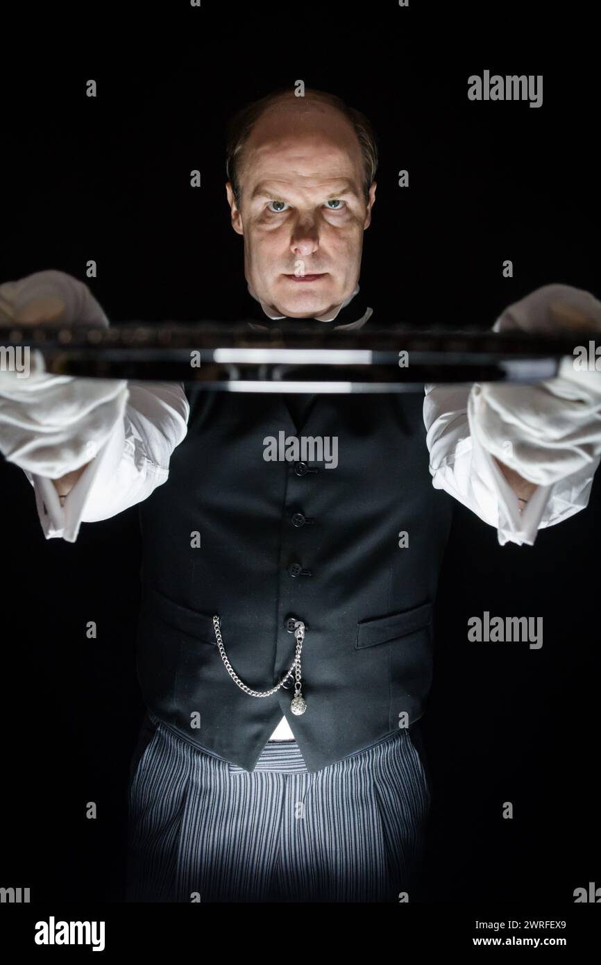 Ritratto di un maggiordomo inquietante che tiene il vassoio di servizio. Il concetto del Butler CE l'ha fatta. Foto Stock