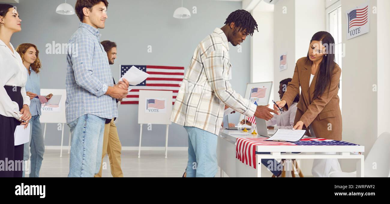 Diversi cittadini americani fanno la fila al tavolo di registrazione al polling station il giorno delle elezioni Foto Stock