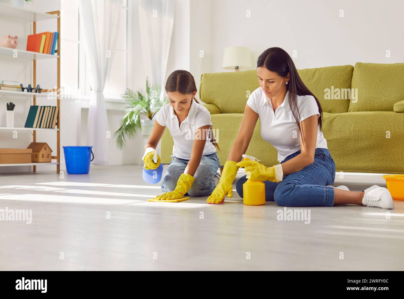 Gioiosa pulizia di madre e figlia a casa Foto Stock