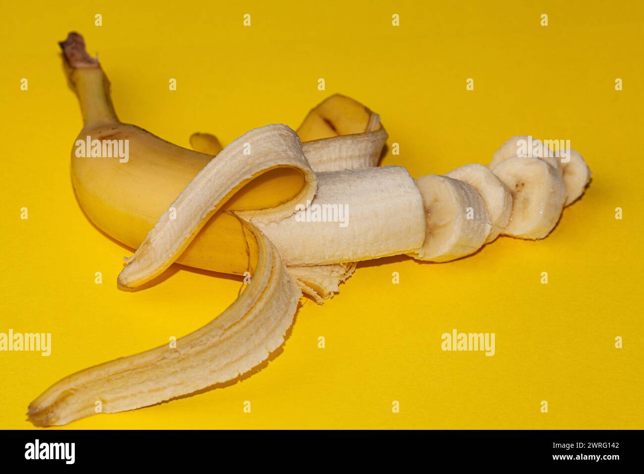Banane fresche mature cadono nell'aria isolate su sfondo giallo. Concetto di levitazione alimentare. Immagine ad alta risoluzione. Foto di alta qualità Foto Stock