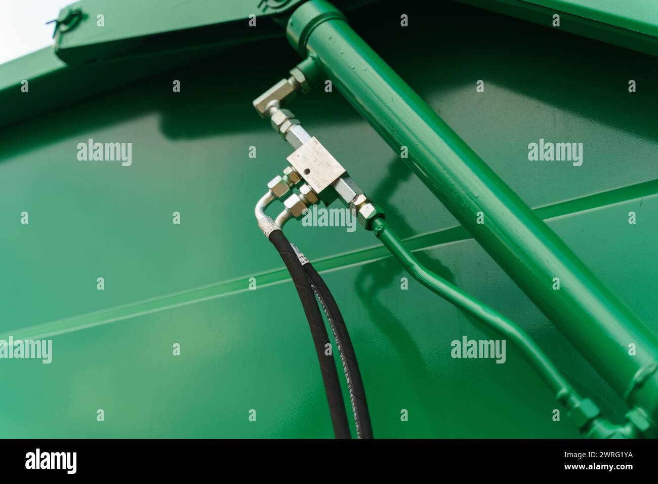 Una vista dettagliata di un tubo collegato saldamente a un serbatoio, pronto per il trasferimento di liquidi o gas. Il collegamento è serrato, garantendo un funzionamento a tenuta ermetica Foto Stock