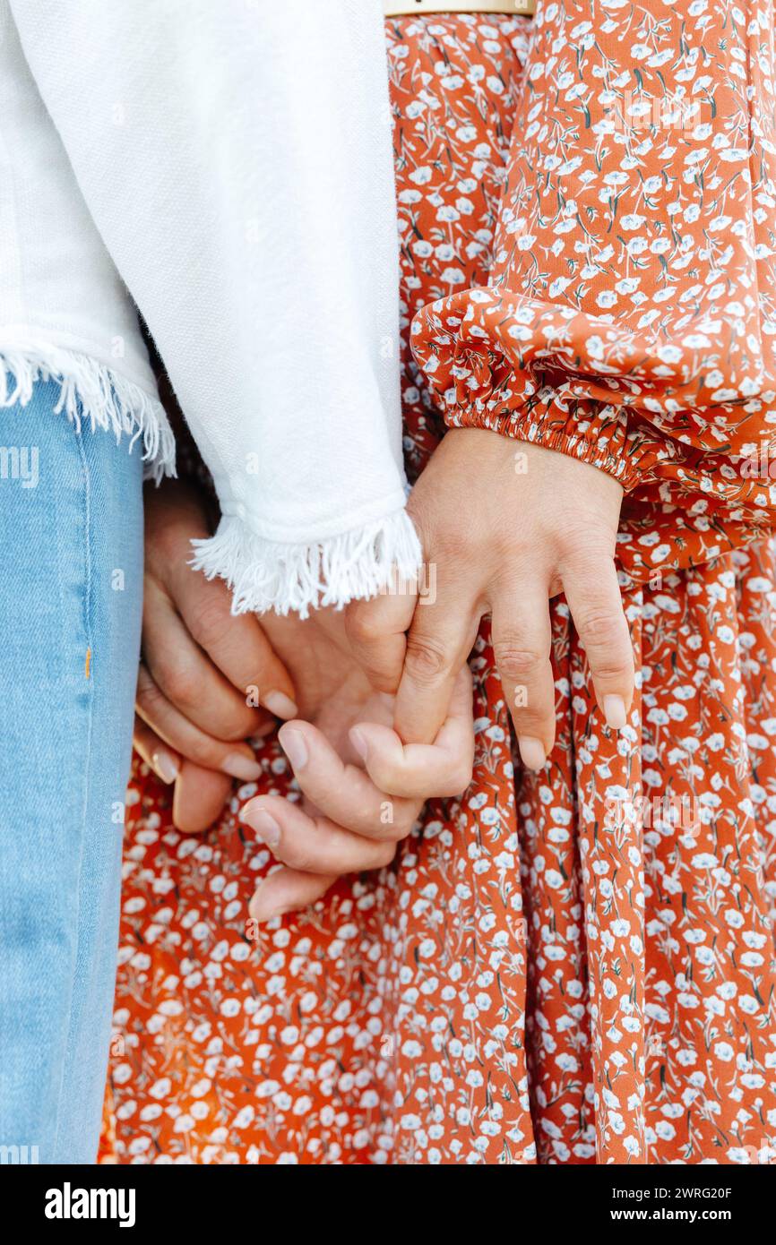 Una visione dettagliata di due individui, le loro mani strette insieme in un forte legame, simboleggiando l'unità e la connessione. Foto Stock