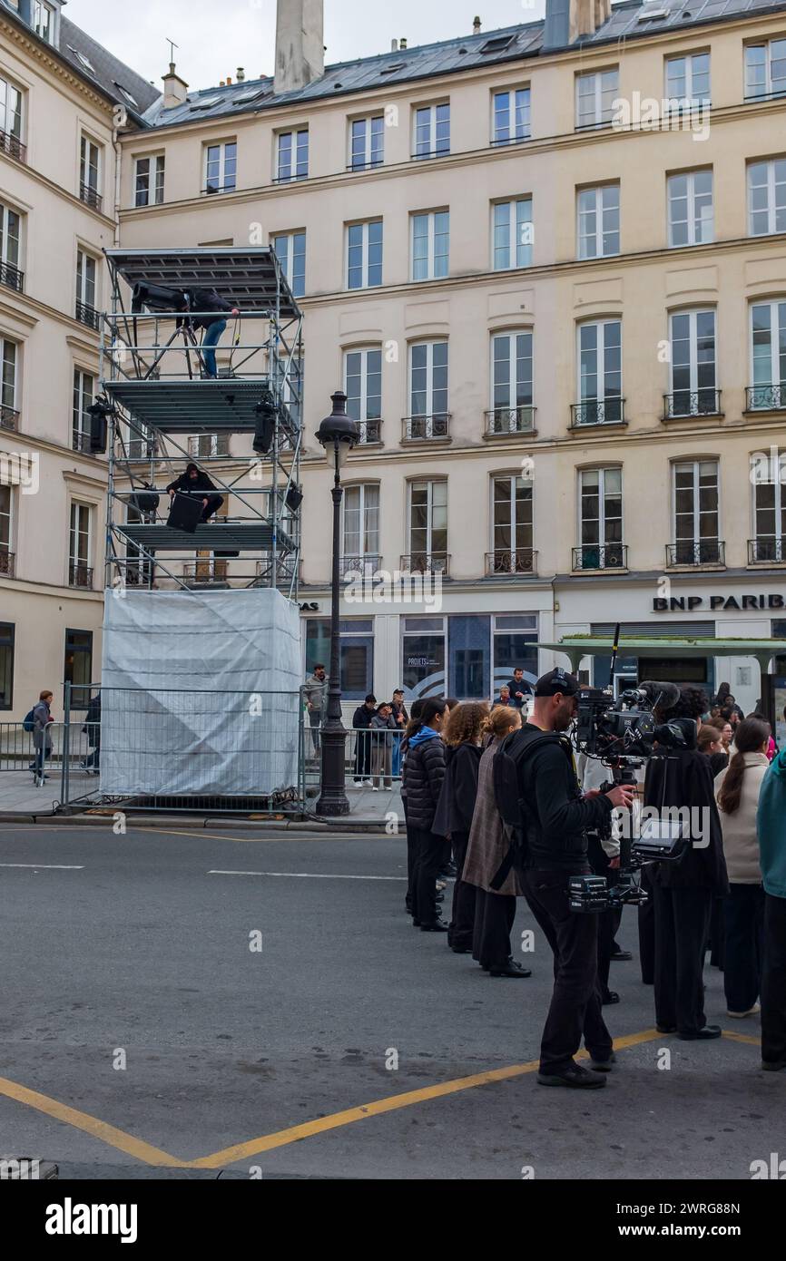 Parigi, Francia, 2024. Un cameraman sta girando delle riprese del coro di giovani che provano rue Soufflot, di fronte al Pantheon (verticale) Foto Stock