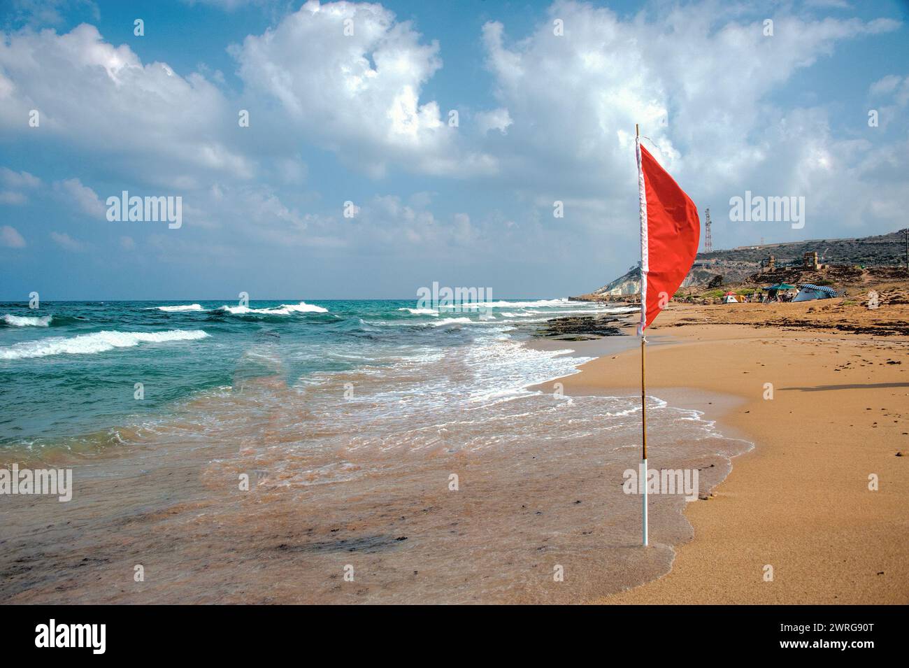 Si avvicina una tempesta e nuotare in mare è proibito e i bagnini hanno appeso una bandiera rossa sulla spiaggia Foto Stock
