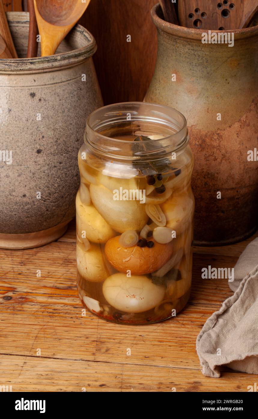 Le uova di pollo sode vengono sottaceto con spezie. . Le gusci d'uovo vengono schiacciate e il recipiente viene refrigerato per circa una settimana Foto Stock