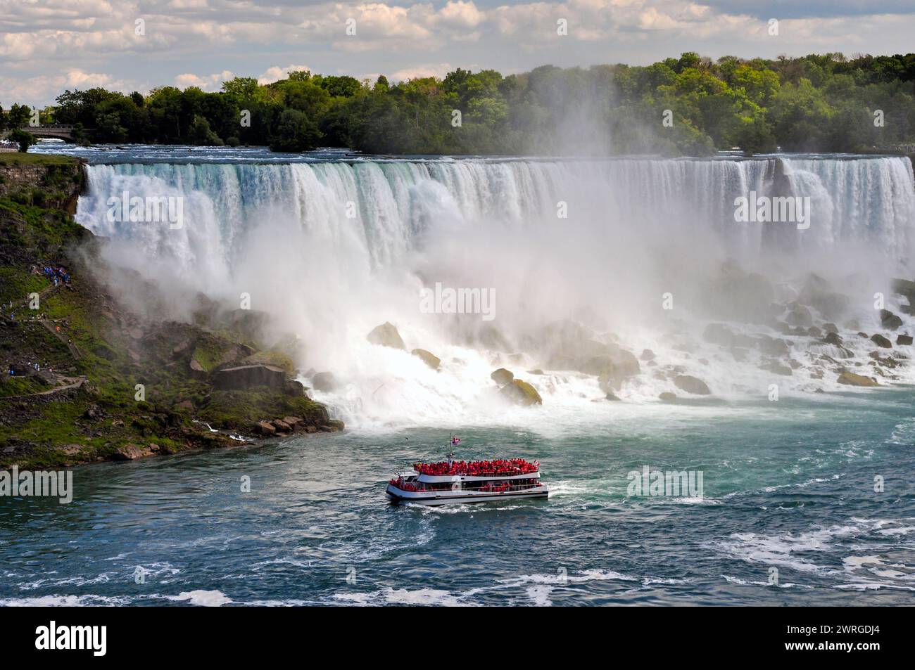 Tour in barca di gruppo Hornblower pieno di folle per tutta l'estate alle Cascate del Niagara, Ontario, Canada. Foto Stock