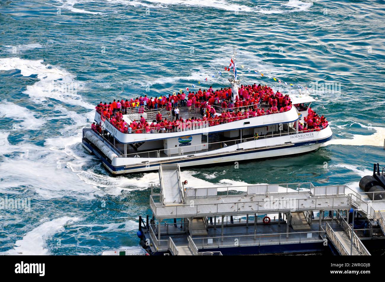 Tour in barca di gruppo Hornblower pieno di folle per tutta l'estate alle Cascate del Niagara, Ontario, Canada. Foto Stock