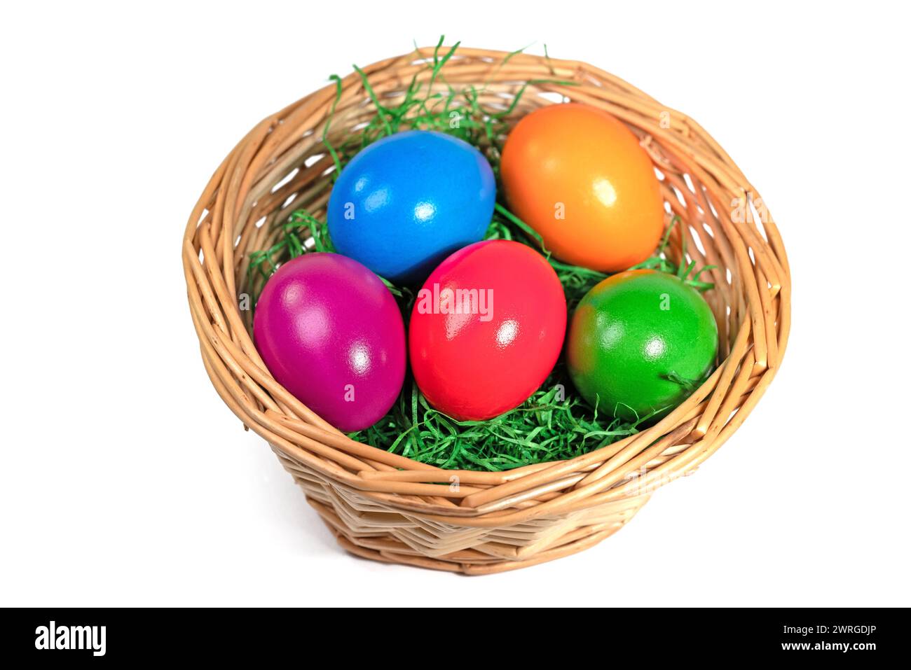 Uova di Pasqua colorate in un cestino su sfondo bianco Foto Stock