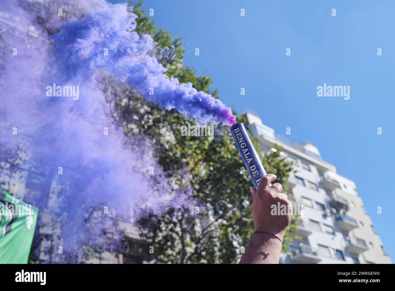 Buenos Aires, Argentina; 8 marzo 2024: Mano che solleva un bagliore di fumo viola in aria durante lo sciopero internazionale delle donne 8M. Foto Stock