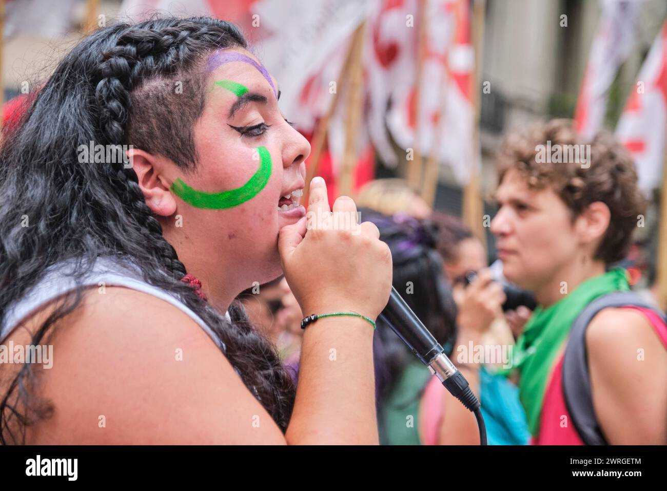 Buenos Aires, Argentina; 8 marzo 2024: Ritratto di una giovane donna con un microfono che canta slogan femministi mentre marcia durante l'internazione Foto Stock