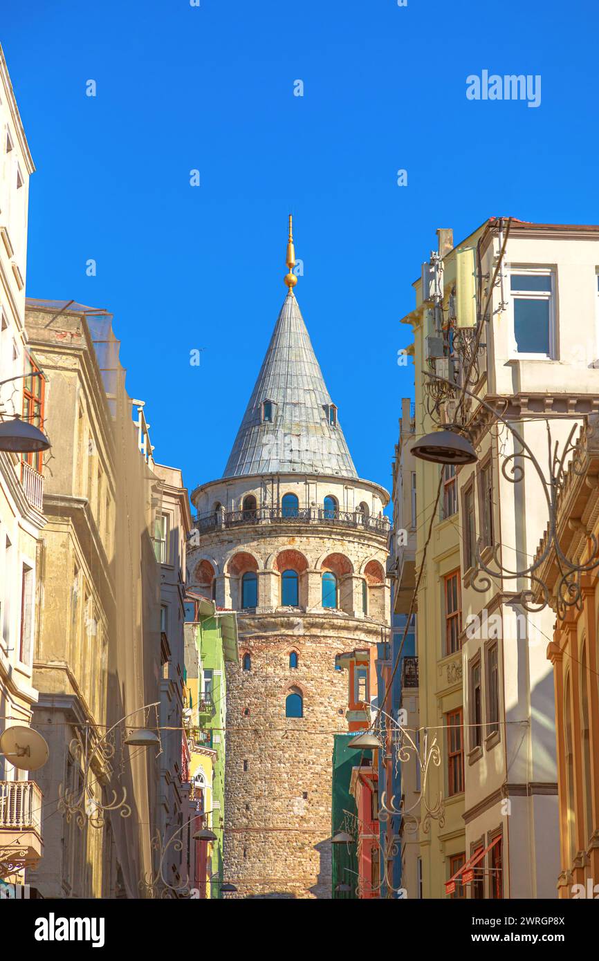 L'antica torre di Galata sorge nel quartiere Galata di Istanbul, incorniciata da antichi edifici contro un cielo azzurro della Turchia. Foto Stock