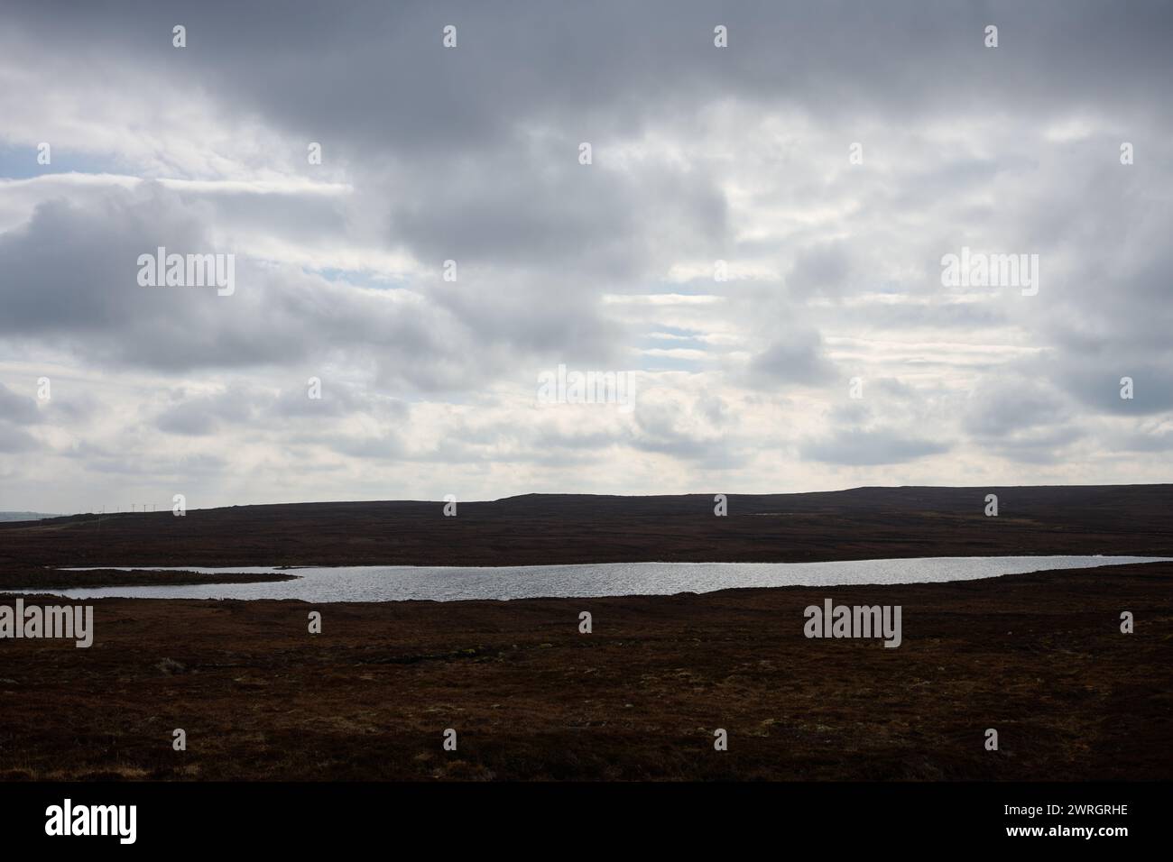 Vista panoramica di un piccolo lago scozzese o lago vicino alle torbiere di Caithness, vicino a Dunnet Head, Highlands Foto Stock