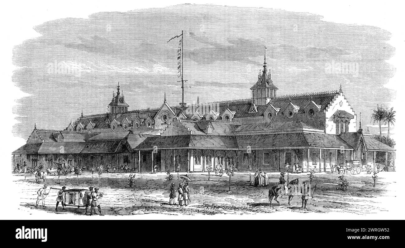 The Punjaub Exhibition Building at Lahore, [India], 1864. "Un'esposizione dei prodotti, dei manufatti e delle arti del Punjaub sta per essere tenuta... l'edificio è in mattoni... con due piccoli annessi... ci sarà anche un annesso temporaneo in...[che] si propone anche di esporre i processi di molti dei più celebri produttori del Punjaub, avendo uomini effettivamente al lavoro nei loro rispettivi mestieri, come il ricamo scialle, il disegno del filo, il broccato d'oro e d'argento (da Delhi) e il gujerati (acciaio intarsiato con oro)... Mr C. Baines, C.E., della ferrovia Punjaub, Foto Stock