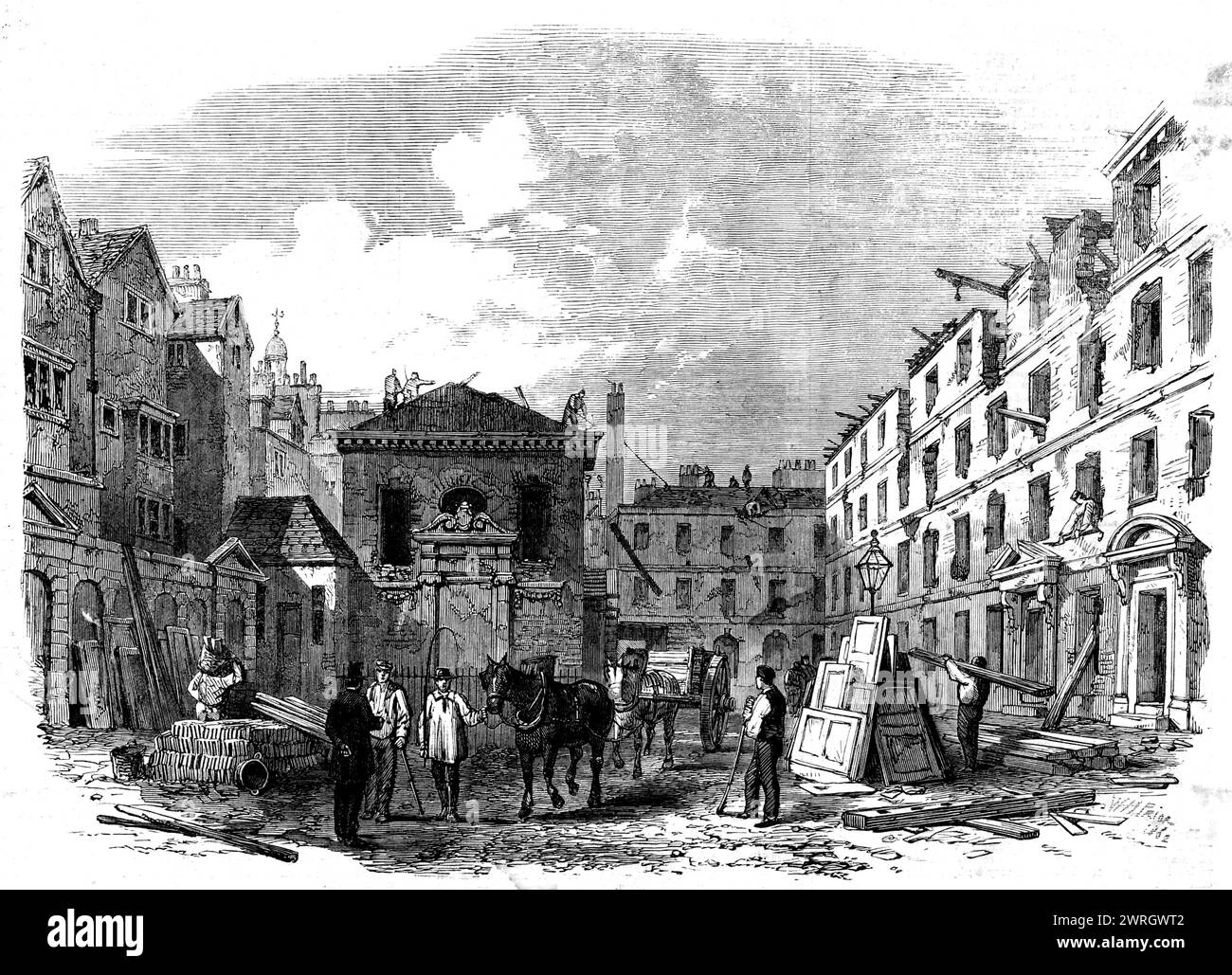 Demolizione di Lyon's Inn, Strand, [Londra], 1862. Un pezzo della vecchia Londra - un angolo a lungo trascurato e fuori strada - è scomparso, dopo essere stato minacciato di distruzione per quasi mezzo secolo. Questo vecchio e degenerato posto era stato, tuttavia, un posto da notare - uno dei vivai dei nostri grandi avvocati - una locanda di Chancery, attaccata alla Parent inn, l'Inner Temple...sul lato nord della strada era rimasta la parte più antica della locanda di Lione, e qui c'era l'ingresso originale, bloccato da molti anni. Aveva un paio di teste di leoni scolpite: Di fronte c'è... una corna Foto Stock