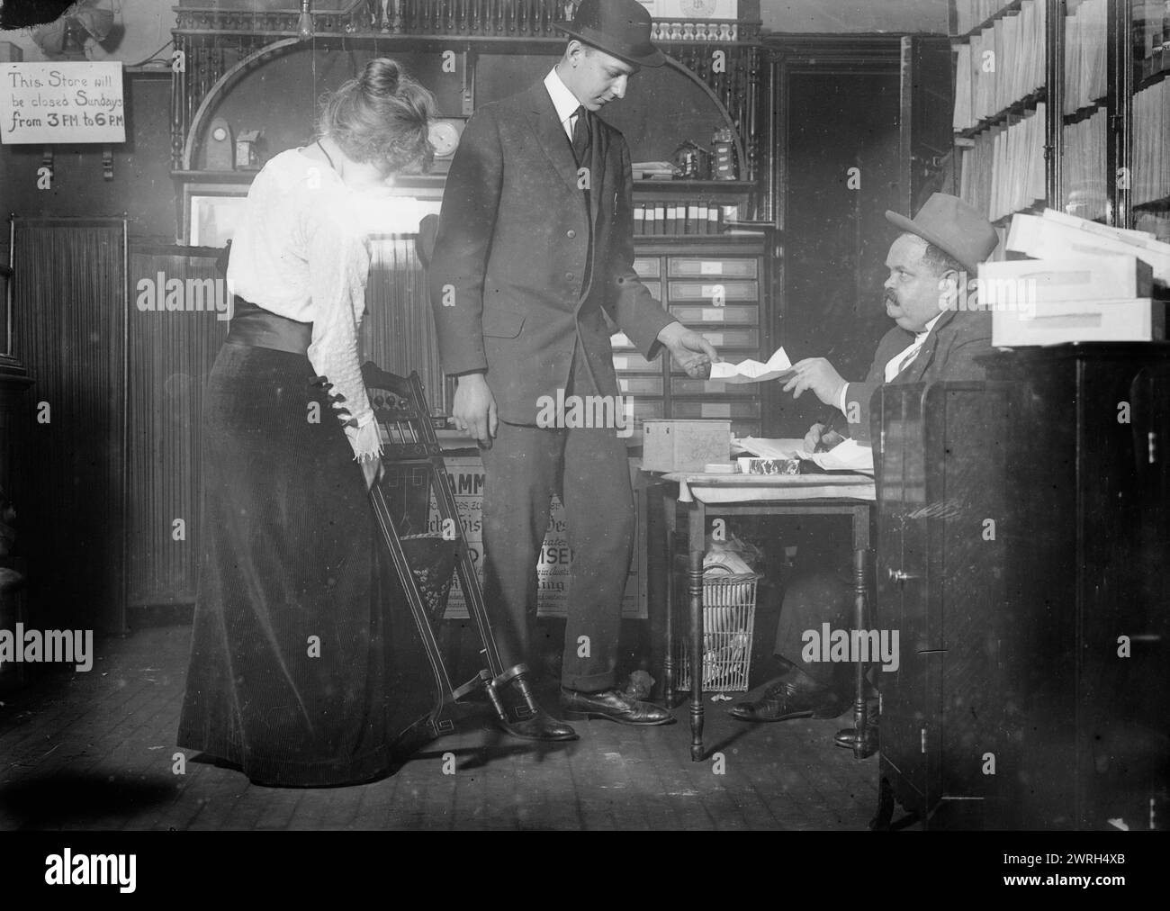 Miss Mielke, 22 ottobre 1914. Henry Mielke (1871) sua figlia Henrietta (1897) e un altro uomo. Henry Mielke era proprietario di un negozio e membro dell'organizzazione "Gold for Iron" (Gold fur Eisen) che dava anelli di ferro alle persone in cambio di oro e gioielli che venivano utilizzati per sostenere lo sforzo bellico tedesco durante la prima guerra mondiale Fotografia probabilmente scattata nel negozio di Mielke situato sulla Second Avenue all'angolo della 87th Street a New York. Foto Stock