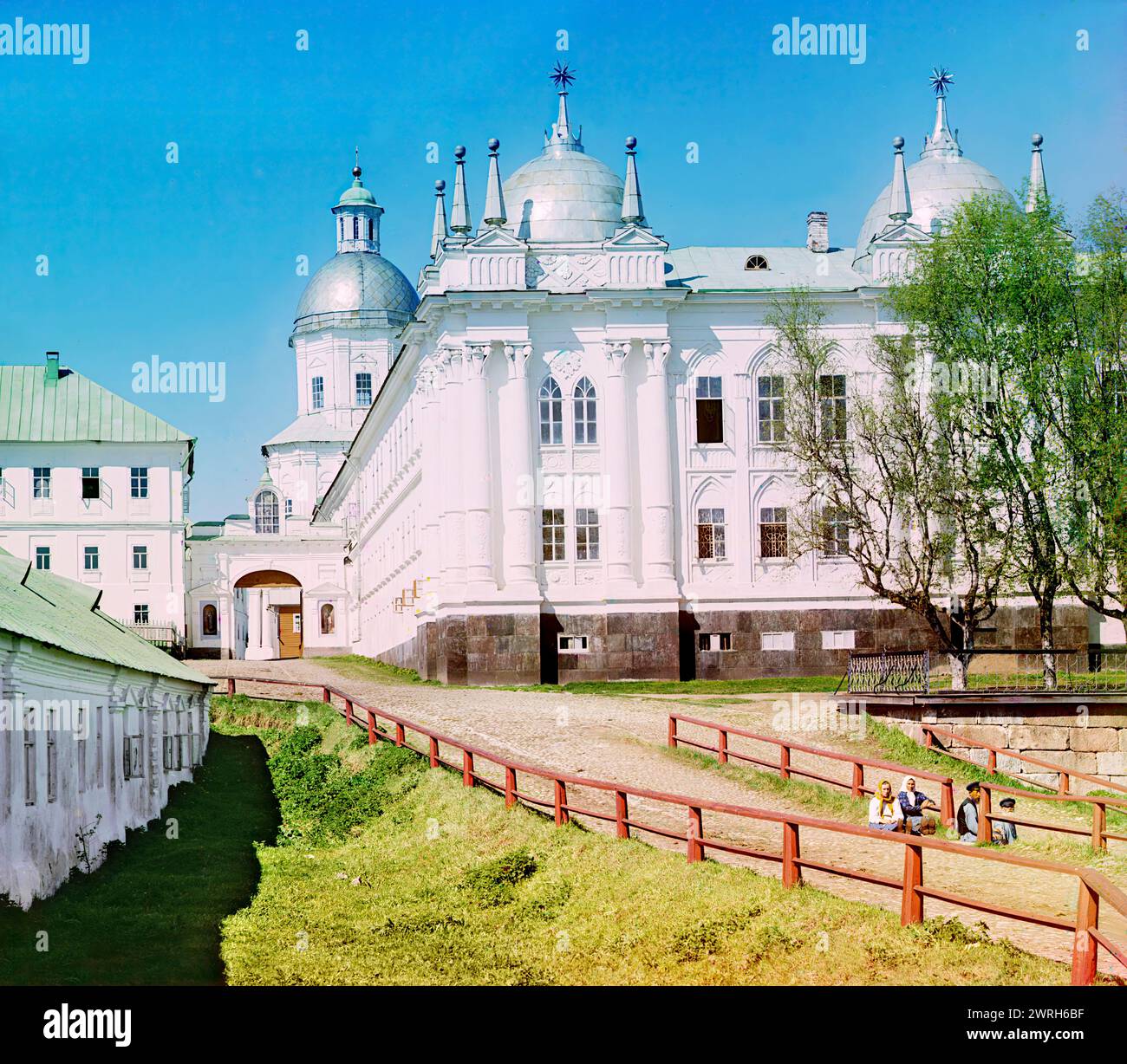 Edificio principale della St. Monastero Nilus Stolobensky, lago Seliger, 1910. Quattro persone sedute sulla strada vicino all'ingresso del monastero. Foto Stock