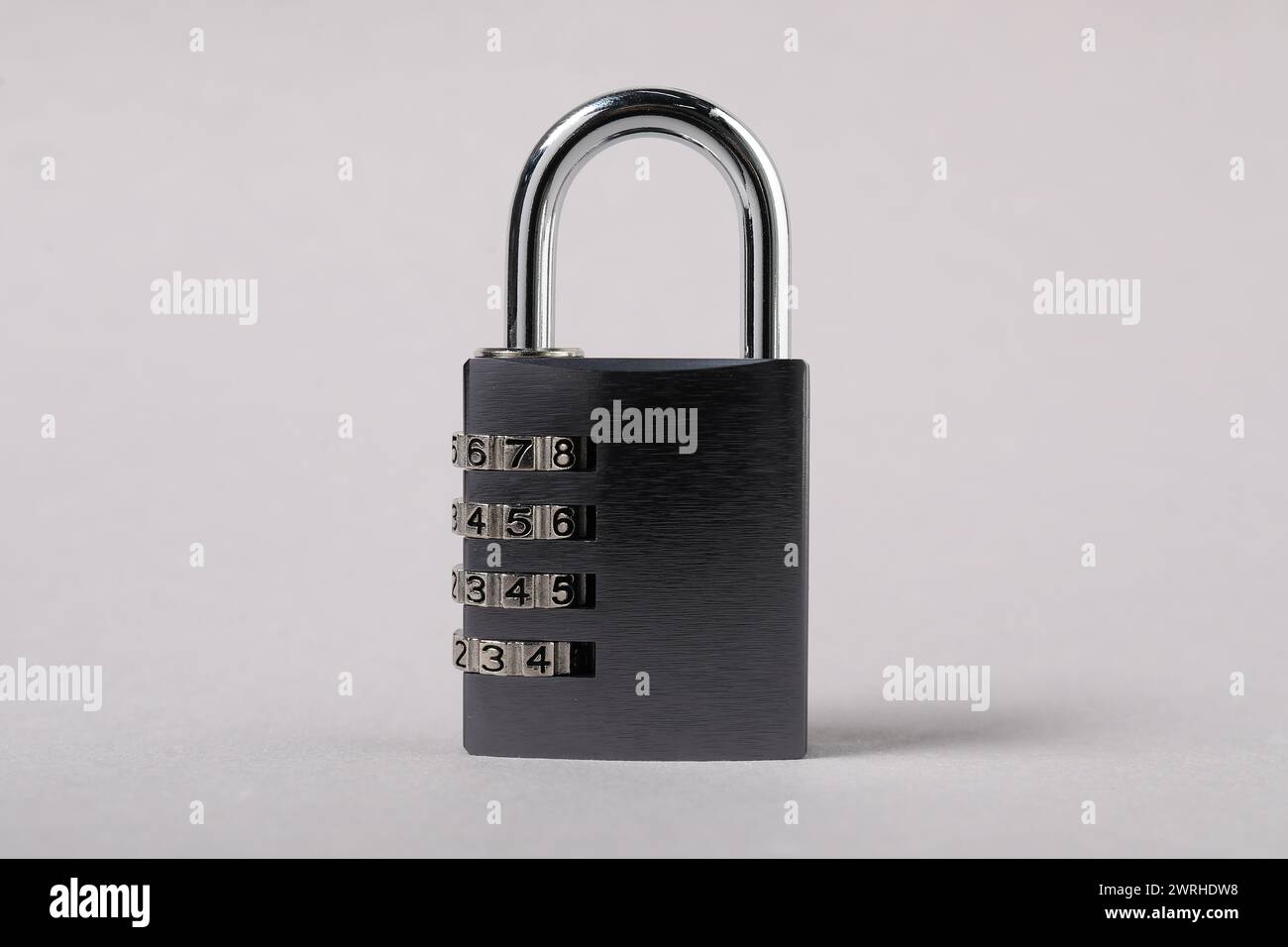 Un lucchetto combinato in acciaio su sfondo grigio, primo piano Foto Stock