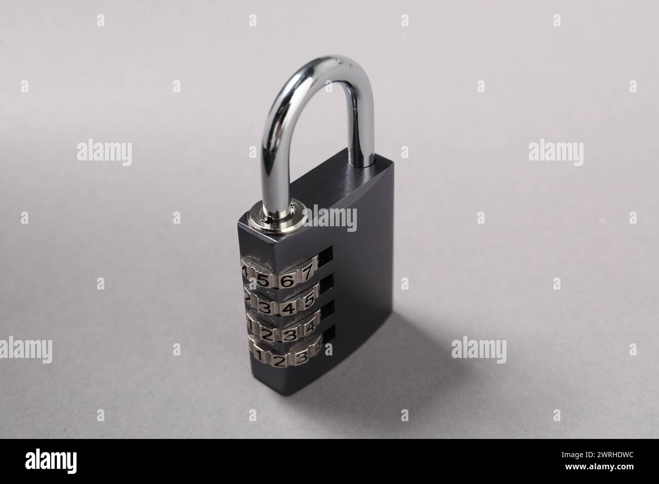 Un lucchetto combinato in acciaio su sfondo grigio, primo piano Foto Stock