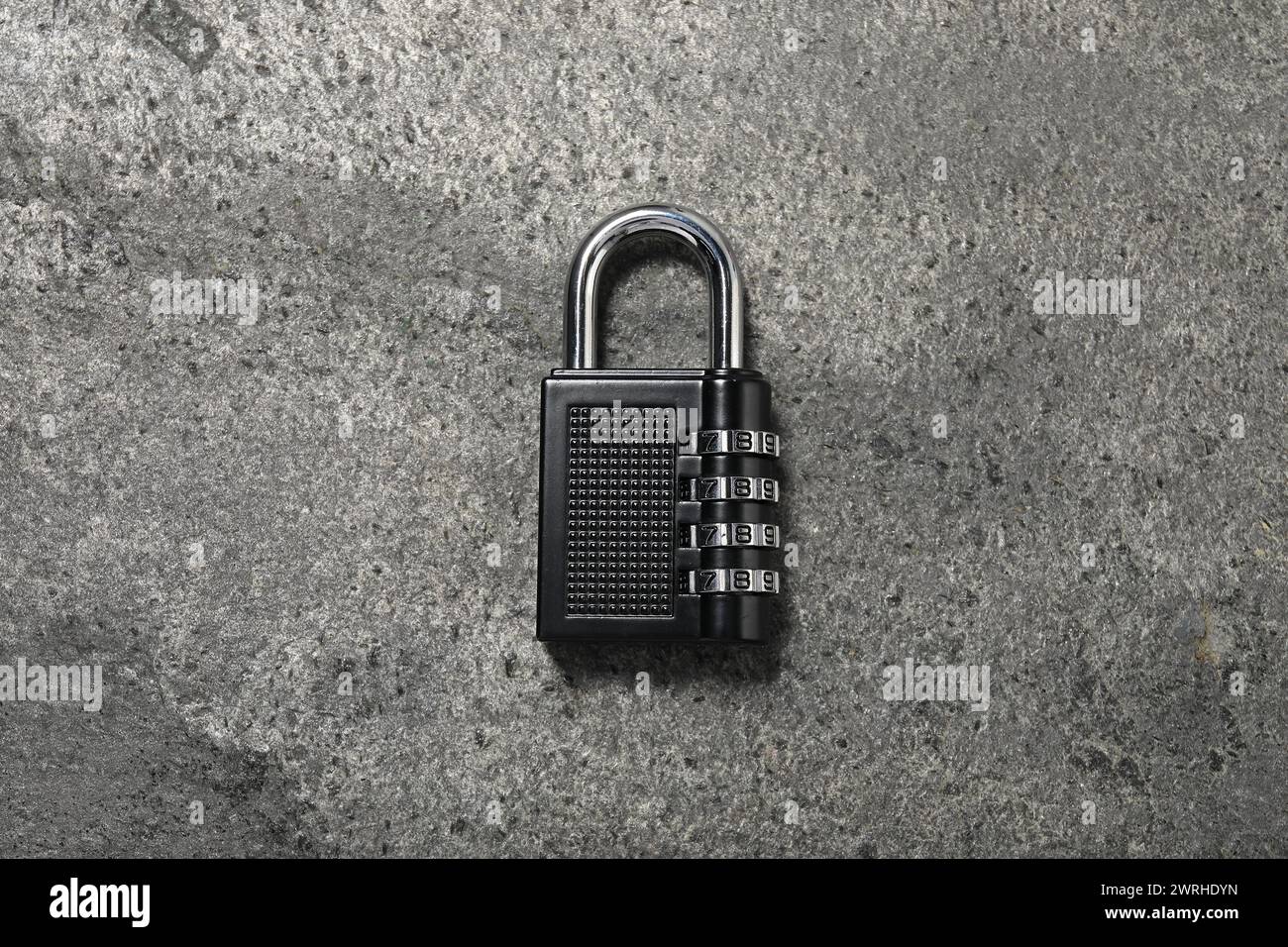 Un lucchetto a combinazione in acciaio sul tavolo grigio, vista dall'alto Foto Stock