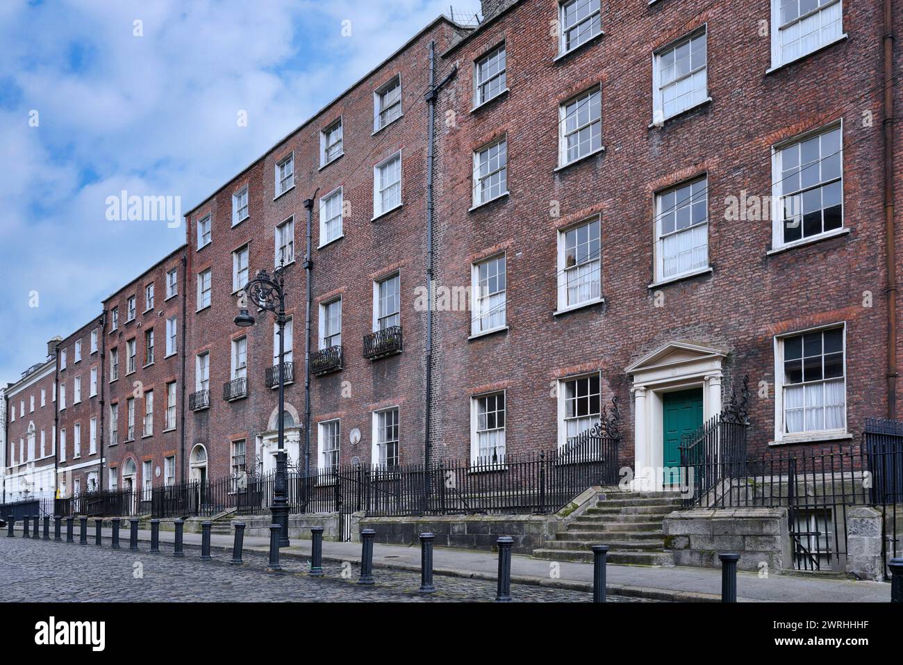 Fila di case cittadine in mattoni del XVIII secolo in una strada acciottolata a Dublino Foto Stock