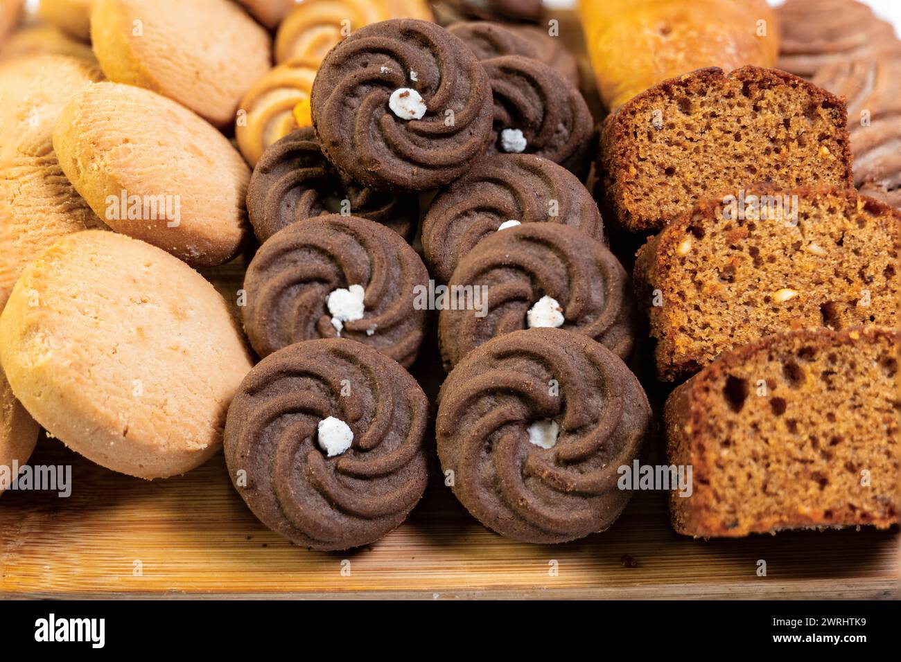 Una vista ravvicinata di una deliziosa selezione di prodotti da forno, tra cui pane, pasticcini e biscotti, tutti esposti su un'affascinante tavola rustica in legno Foto Stock