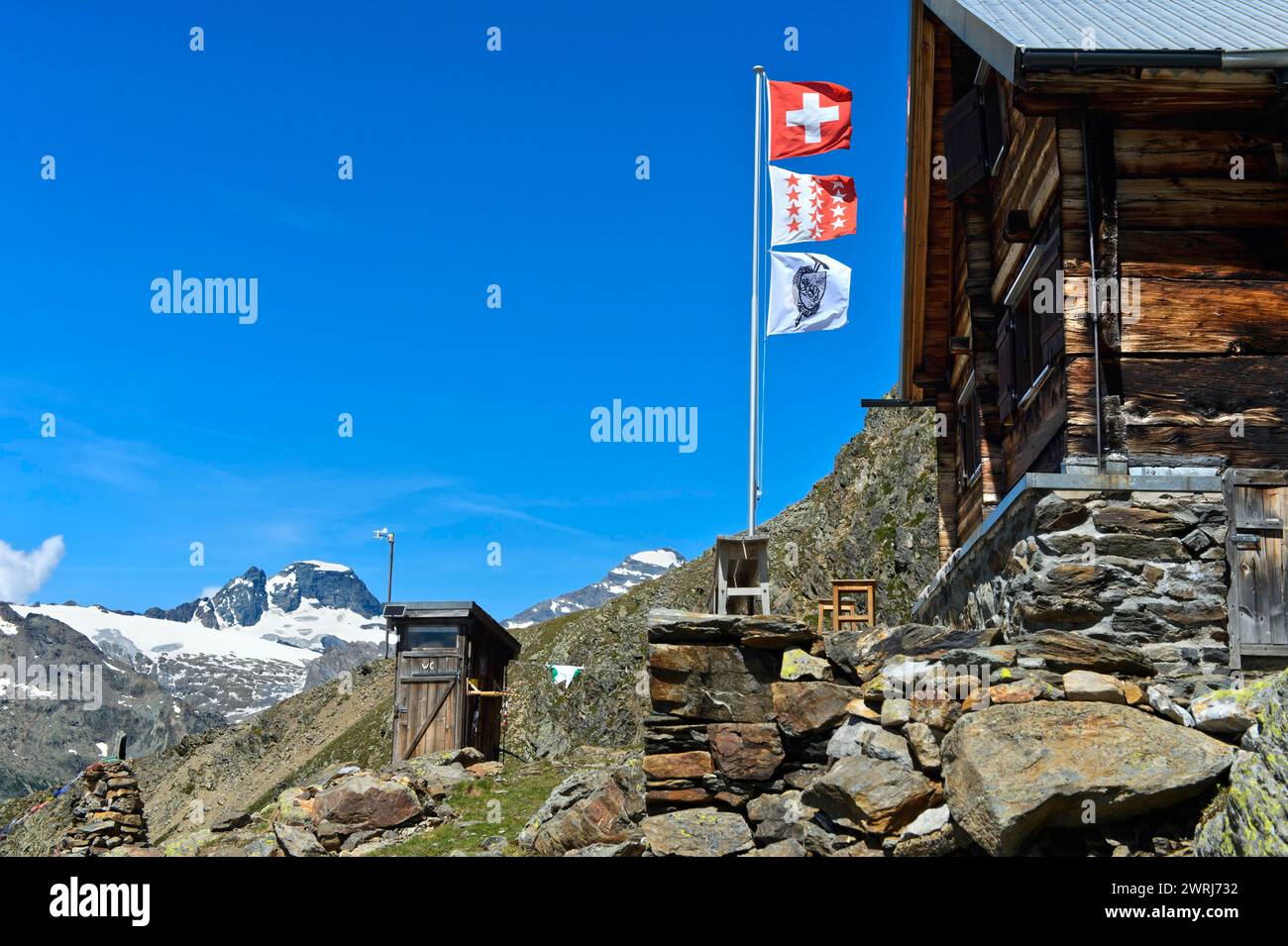Flagpole con le bandiere della Svizzera, del Canton Vallese e del Club Alpino accademico di Berna AACB al rifugio Bietschhorn di Loetschental, Vallese Foto Stock