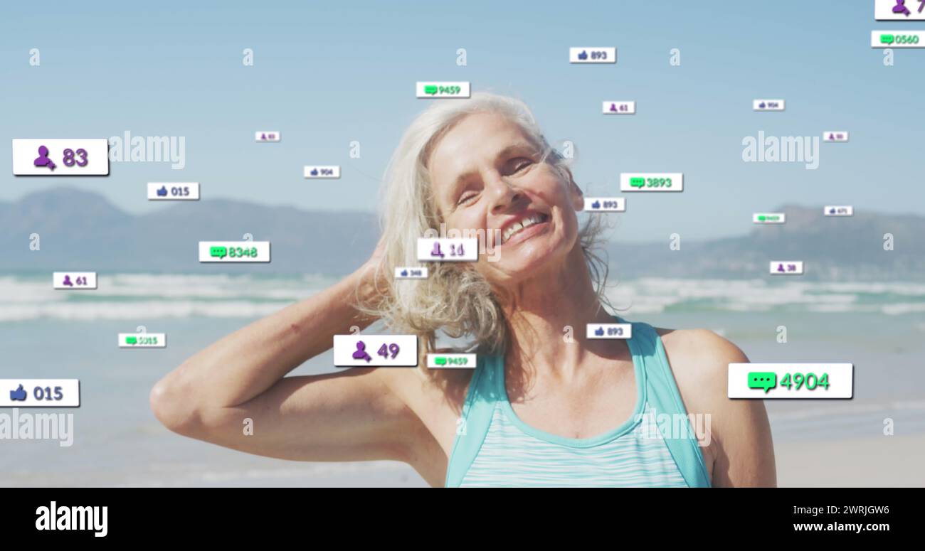 Immagine delle notifiche sui social media, su una donna anziana che sorride sulla spiaggia Foto Stock