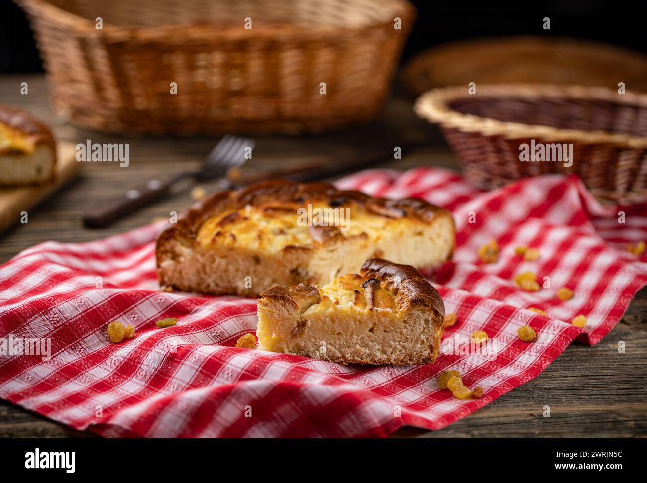 Torta in casseruola di formaggio fresco con uva passa su tovaglia rustica Foto Stock
