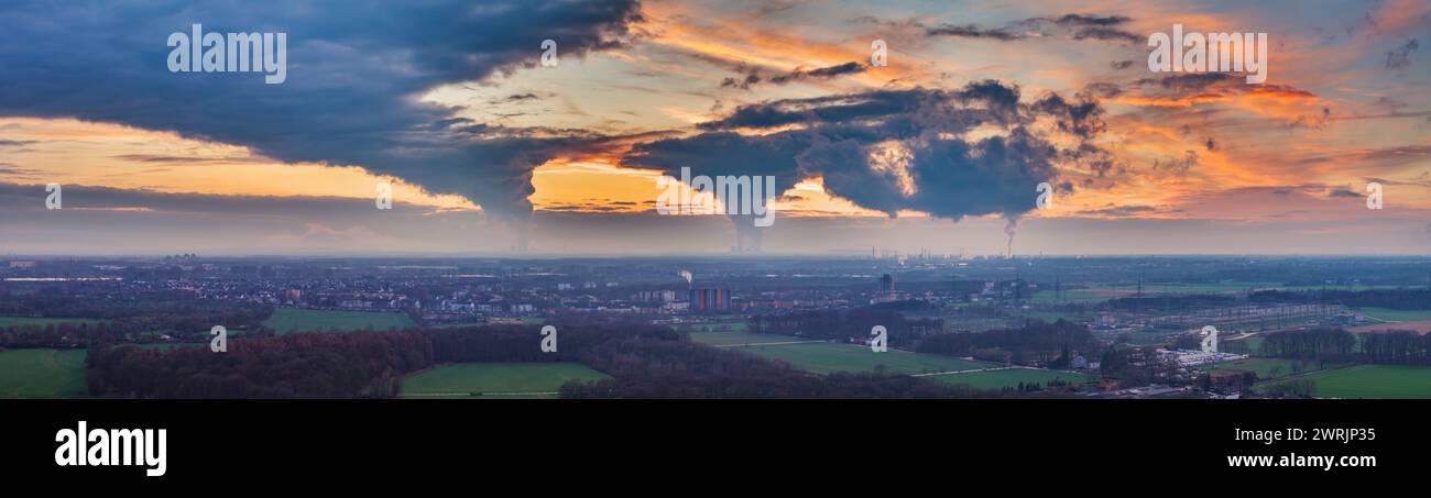Immagine droni del cielo serale della regione industriale tedesca della Ruhr con diversi camini che emettono grandi quantità di gas di scarico in inverno Foto Stock